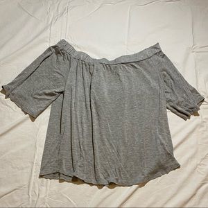 Off the shoulder grey shirt.
